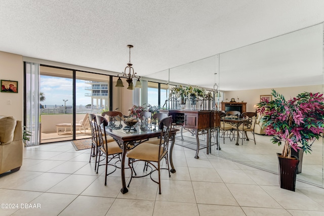 dining room with a wall of windows, a textured ceiling, and light tile patterned floors