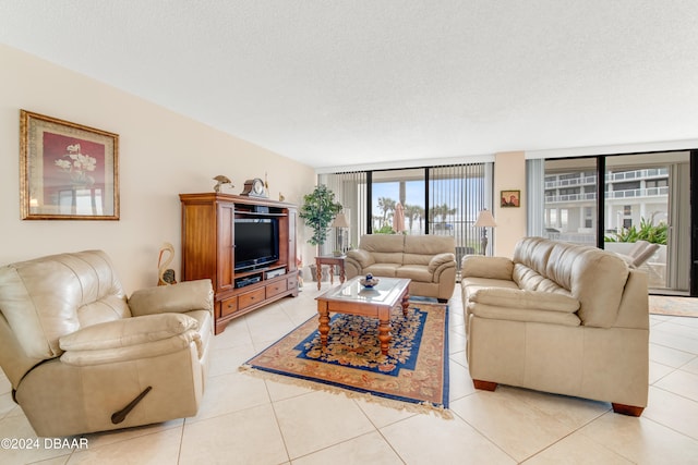 tiled living room with a textured ceiling and floor to ceiling windows