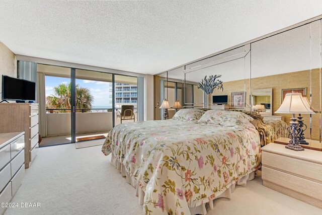 901 S Atlantic Ave Unit 102, Ormond Beach, FL 32176 - bedroom featuring access to exterior, a textured ceiling, and carpet
