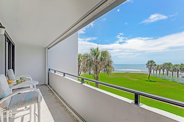 balcony featuring a water view and a view of the beach