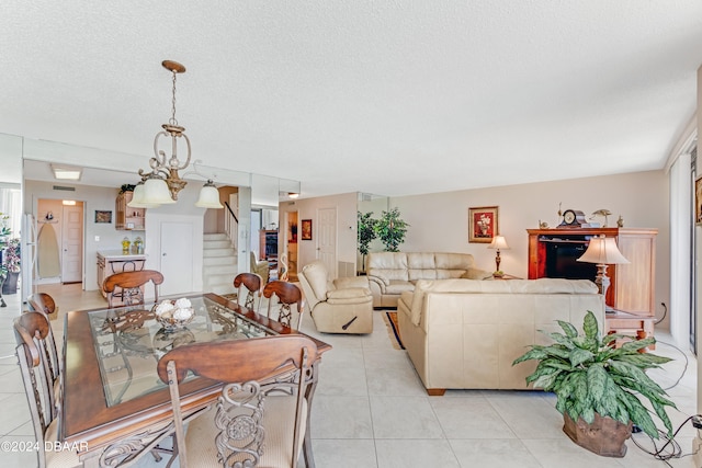 living room with a textured ceiling, an inviting chandelier, and light tile patterned flooring