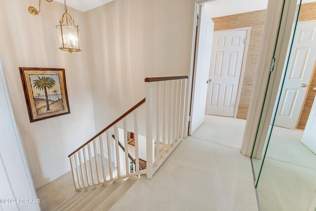 901 S Atlantic Ave Unit 102, Ormond Beach, FL 32176 - corridor with an upstairs landing, a chandelier, and carpet flooring