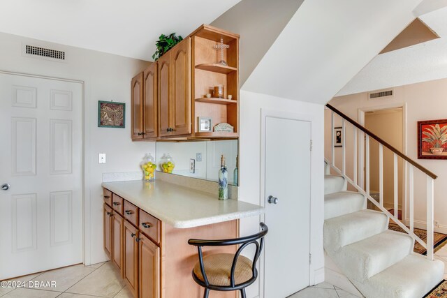 901 S Atlantic Ave Unit 102, Ormond Beach, FL 32176 - bar area featuring stairway and light tile patterned floors