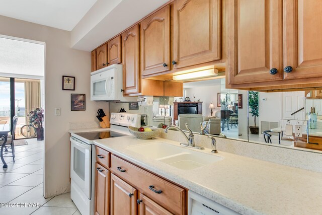 901 S Atlantic Ave Unit 102, Ormond Beach, FL 32176 - kitchen featuring white appliances, a sink, light tile patterned floors, and brown cabinets