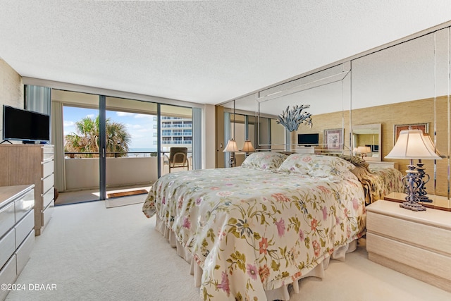 bedroom with light carpet, a textured ceiling, access to outside, and expansive windows