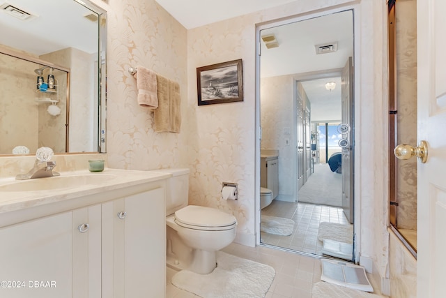 bathroom with tile patterned floors, vanity, toilet, and walk in shower