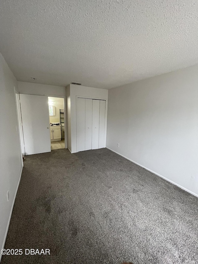 403 Banana Cay Dr Unit B, South Daytona, FL 32119 - unfurnished bedroom featuring a textured ceiling, a closet, carpet floors, and baseboards