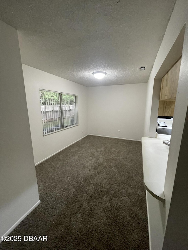 403 Banana Cay Dr Unit B, South Daytona, FL 32119 - unfurnished room with dark carpet, a textured ceiling, and baseboards