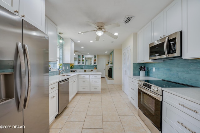 kitchen with light tile patterned floors, stainless steel appliances, a sink, visible vents, and light countertops