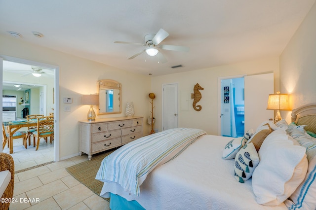 bedroom featuring a ceiling fan, visible vents, and light tile patterned floors