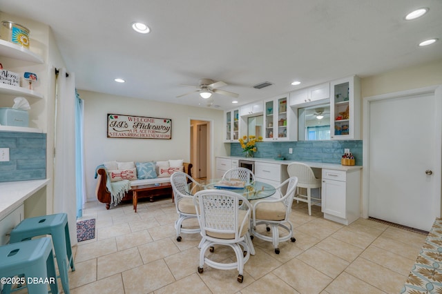 dining space featuring built in desk, ceiling fan, and light tile patterned floors