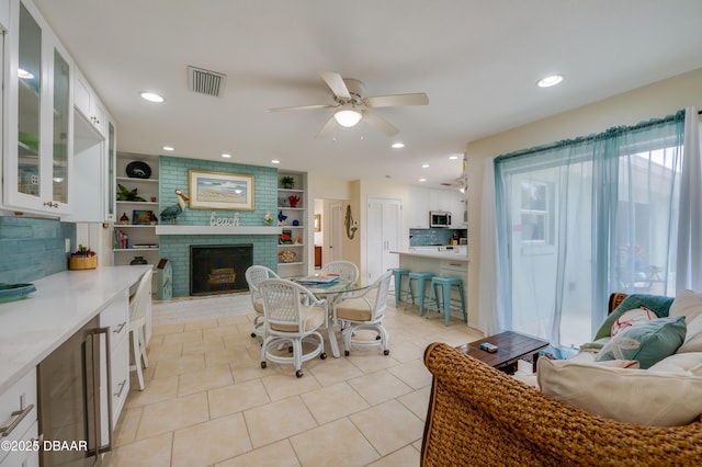 dining area featuring a fireplace, light tile patterned floors, recessed lighting, visible vents, and a ceiling fan