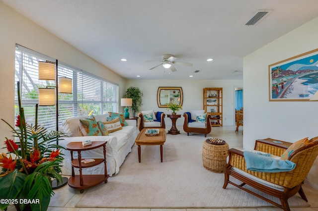 carpeted living room with ceiling fan, visible vents, and recessed lighting