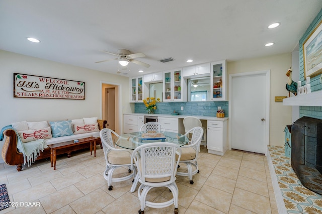 dining area with light tile patterned floors, wine cooler, visible vents, a ceiling fan, and a brick fireplace