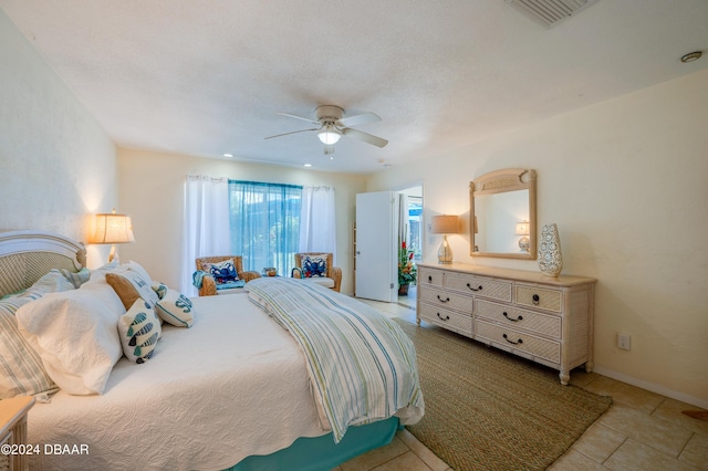 bedroom featuring ceiling fan, visible vents, baseboards, and tile patterned floors