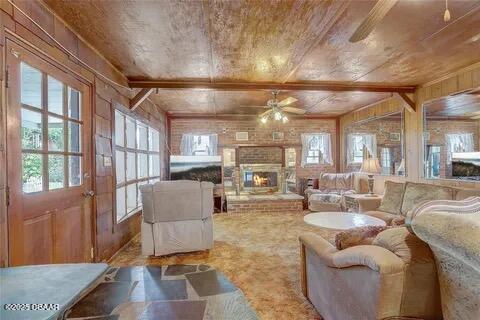 2144 Ridge Dr, Winter Park, FL 32792 - living room with ceiling fan, wood walls, wooden ceiling, and a brick fireplace