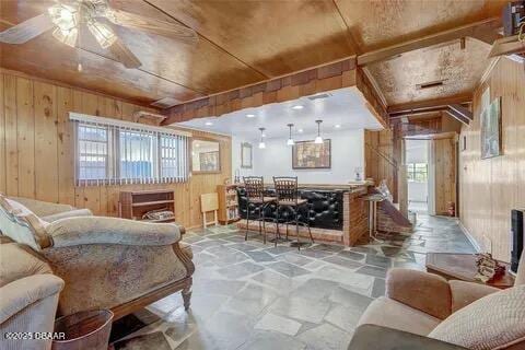 2144 Ridge Dr, Winter Park, FL 32792 - living area featuring wood walls, stone flooring, and ceiling fan