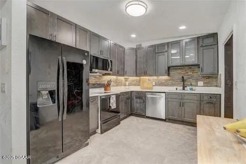 2144 Ridge Dr, Winter Park, FL 32792 - kitchen with stainless steel appliances, a sink, decorative backsplash, light countertops, and recessed lighting