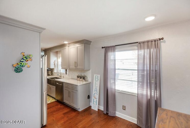 kitchen featuring stainless steel appliances, light countertops, gray cabinetry, and wood finished floors