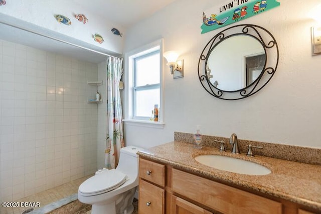 full bathroom featuring vanity, a tile shower, and toilet