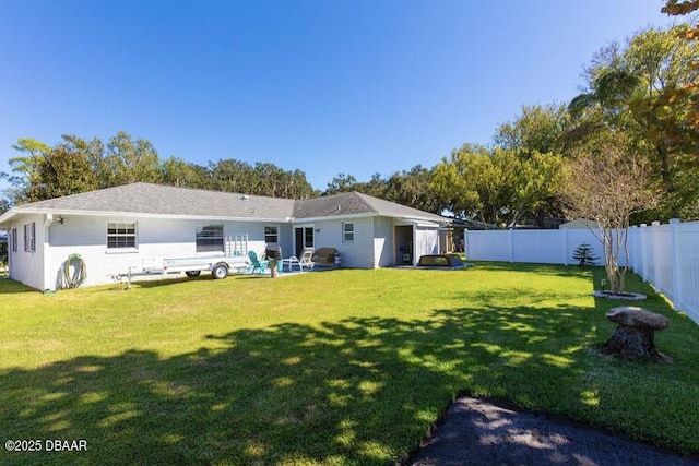 back of house featuring a fenced backyard, a lawn, and a patio