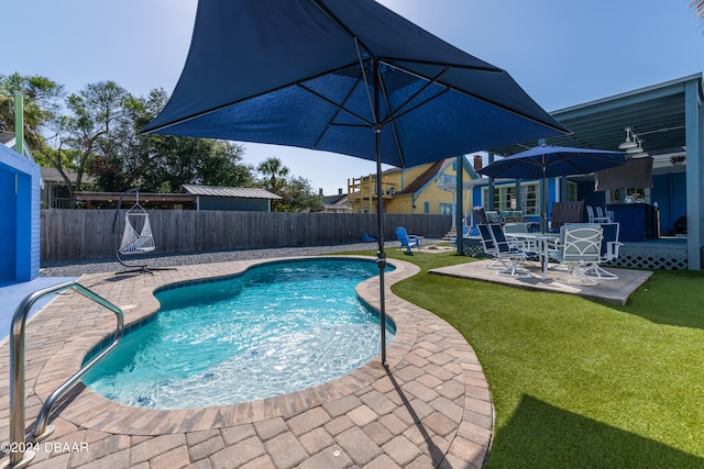 view of pool with a patio area and a lawn