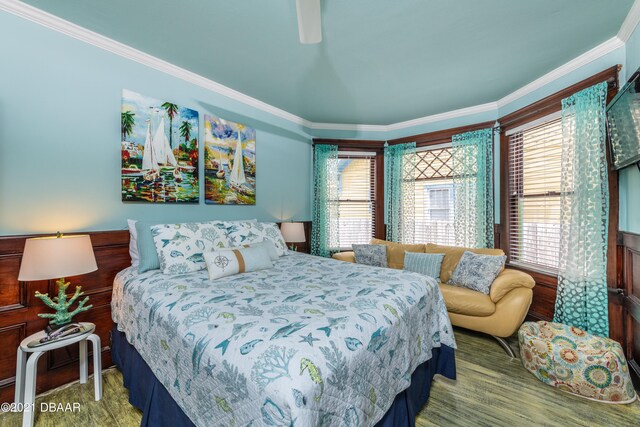 bedroom with hardwood / wood-style floors, ceiling fan, and crown molding