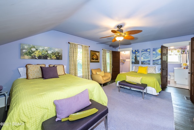 bedroom featuring dark hardwood / wood-style flooring, vaulted ceiling, ensuite bathroom, ceiling fan, and a spacious closet