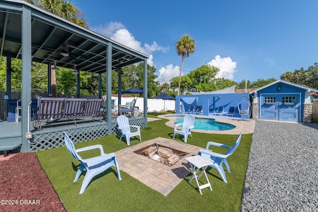 exterior space with an outdoor structure, a fire pit, and a swimming pool side deck