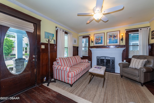 living room featuring dark hardwood / wood-style flooring, ceiling fan, and crown molding