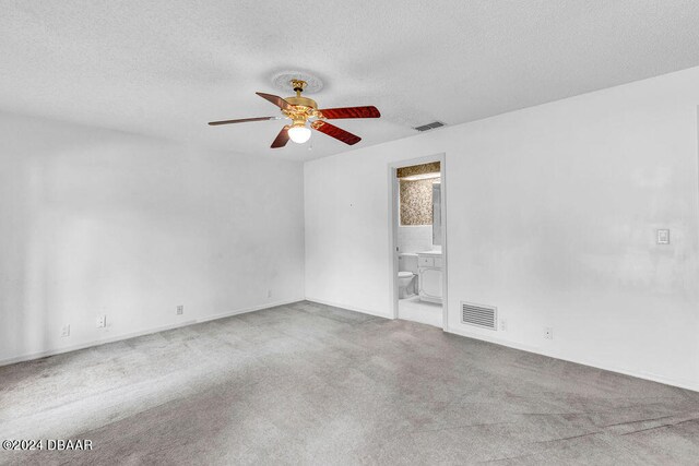 unfurnished room with ceiling fan, light colored carpet, and a textured ceiling