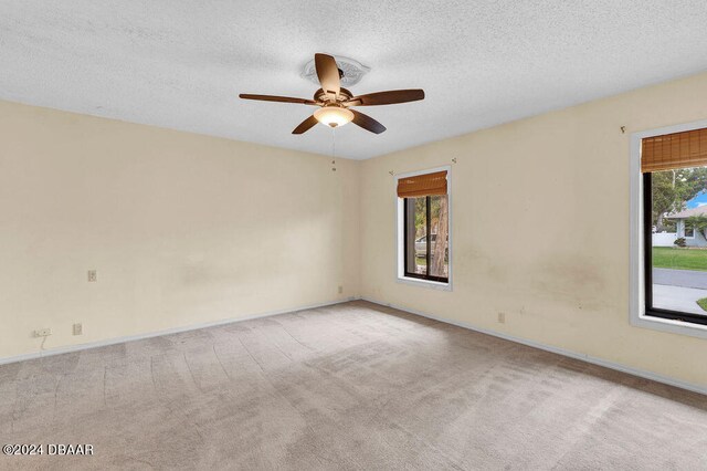 carpeted empty room with a textured ceiling and ceiling fan