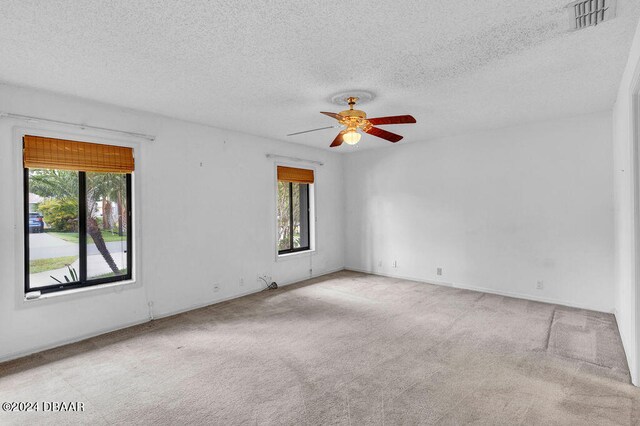 carpeted spare room with a textured ceiling and ceiling fan