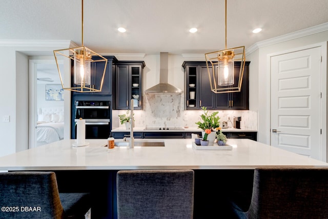 kitchen with dobule oven black, decorative backsplash, wall chimney exhaust hood, ornamental molding, and light countertops