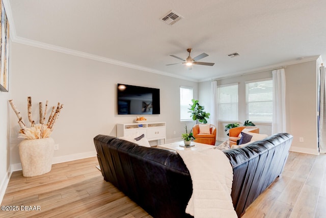 living area with ornamental molding, light wood-type flooring, and visible vents