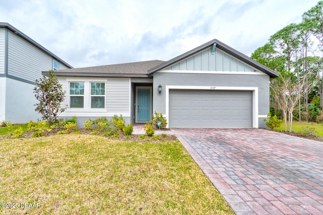 ranch-style house featuring board and batten siding, decorative driveway, a front lawn, and a garage