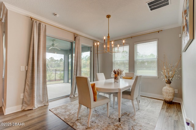 dining area with baseboards, ornamental molding, visible vents, and light wood-style floors