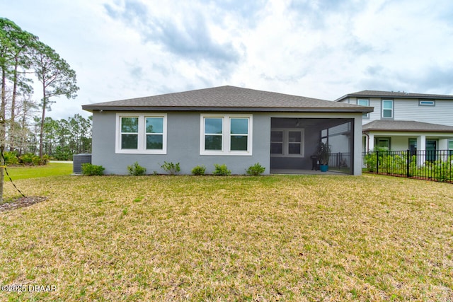 rear view of house featuring a yard, stucco siding, a sunroom, fence, and cooling unit