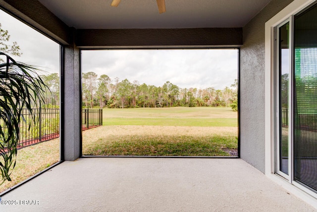 unfurnished sunroom featuring ceiling fan