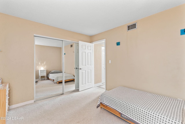 bedroom with light carpet and a closet