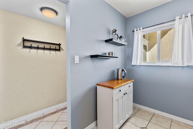 bathroom featuring tile patterned flooring and a textured ceiling