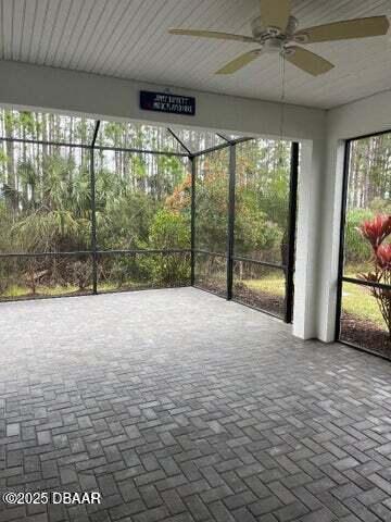 unfurnished sunroom with a ceiling fan