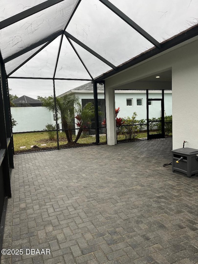 view of patio featuring a lanai and a water view