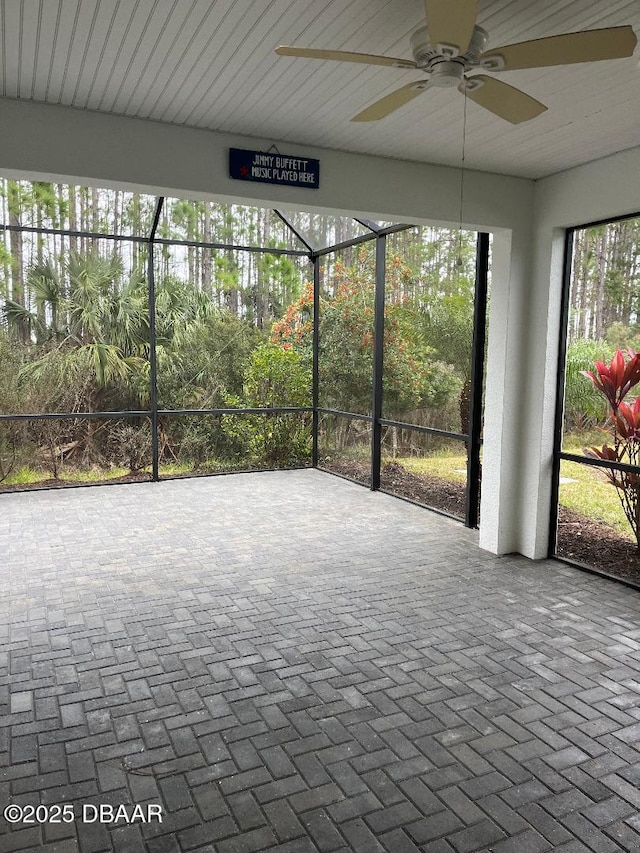 unfurnished sunroom with ceiling fan