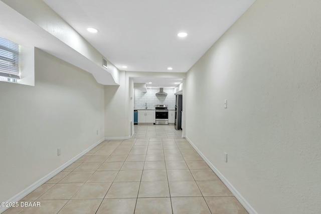 hall with sink and light tile patterned flooring