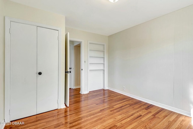 unfurnished bedroom with light hardwood / wood-style floors and a closet