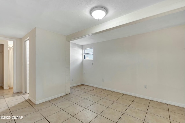 empty room featuring light tile patterned floors and a textured ceiling