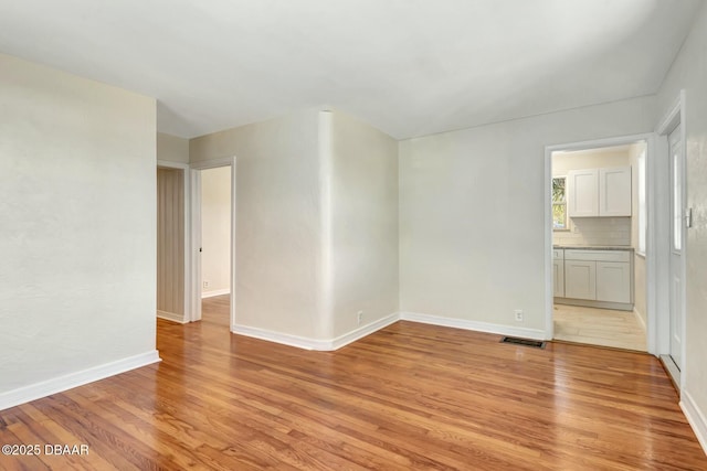 empty room with light hardwood / wood-style flooring