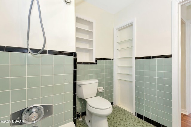 bathroom with tile walls and toilet