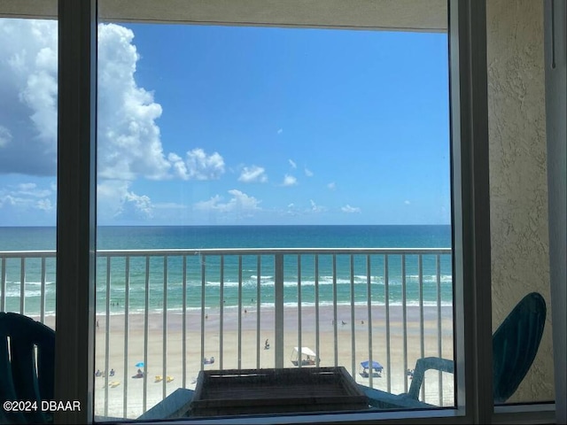 balcony featuring a view of the beach and a water view